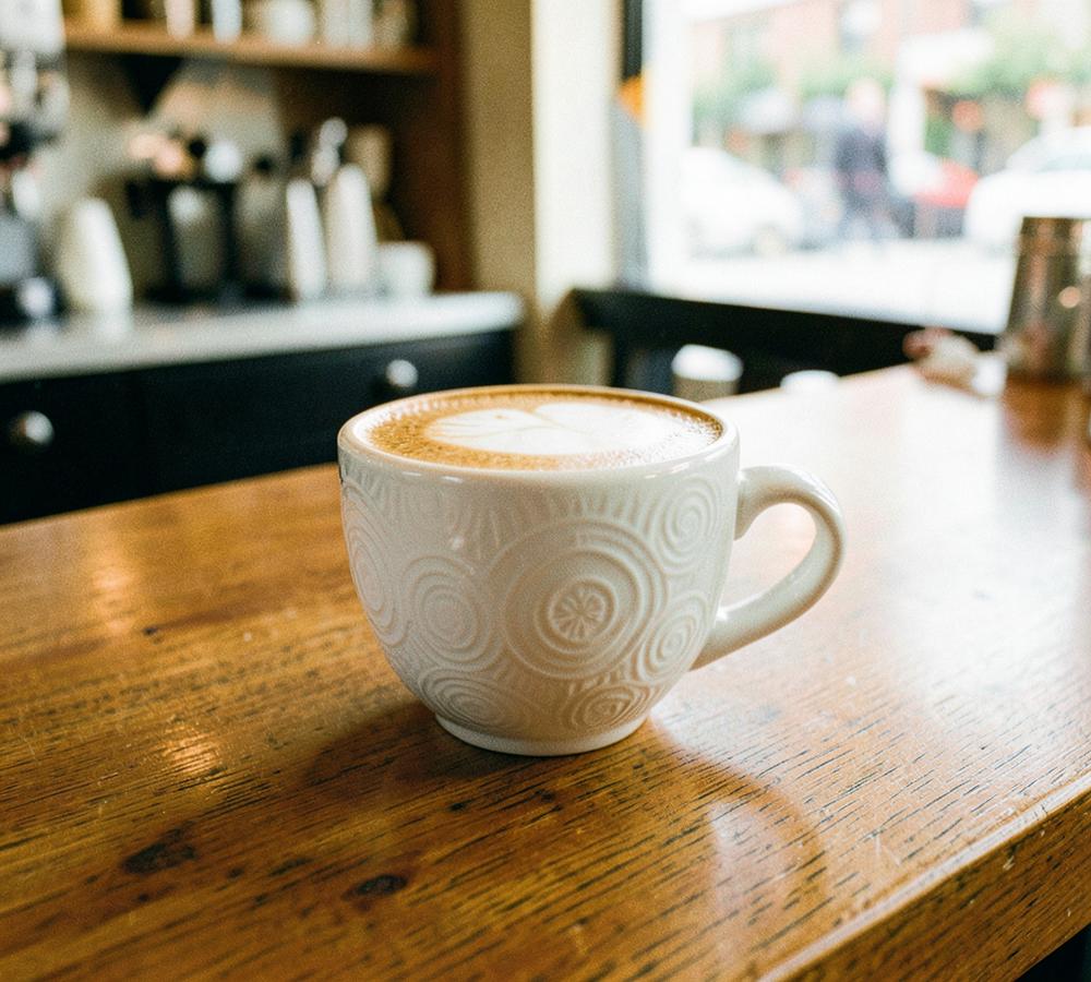 An oat flat white on the café counter
